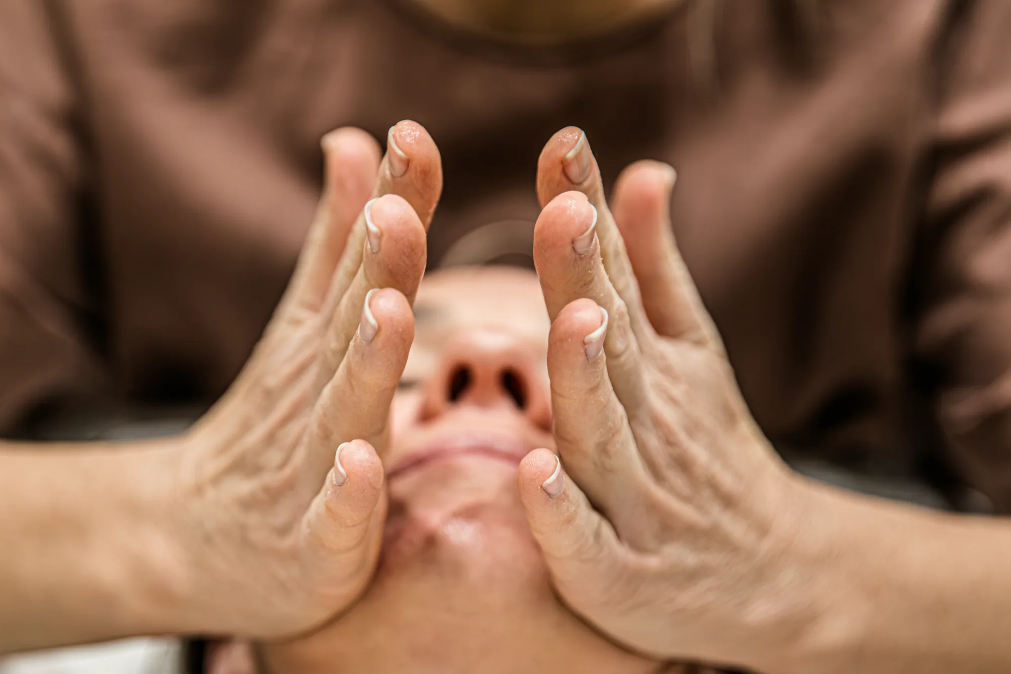 Hands performing sculpting facial massage on a client in Echuca